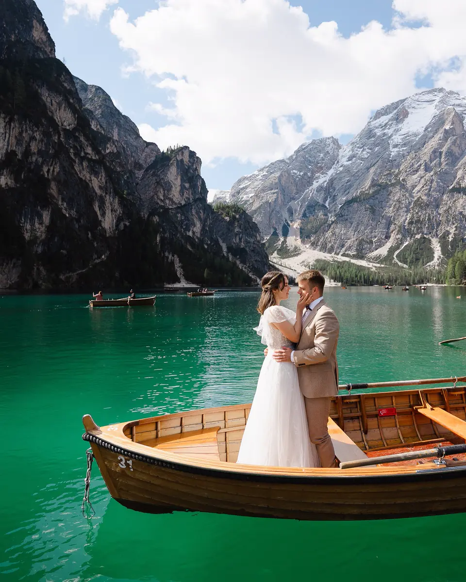 Para Młoda w drewnianej łodzi na turkusowym jeziorze w Dolomitach