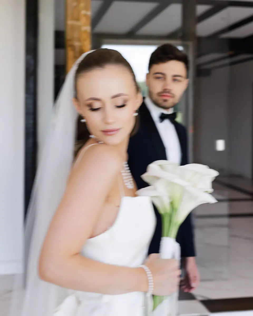 Panna Młoda z kaliami i Pan Młody w smokingu, portret z bliska